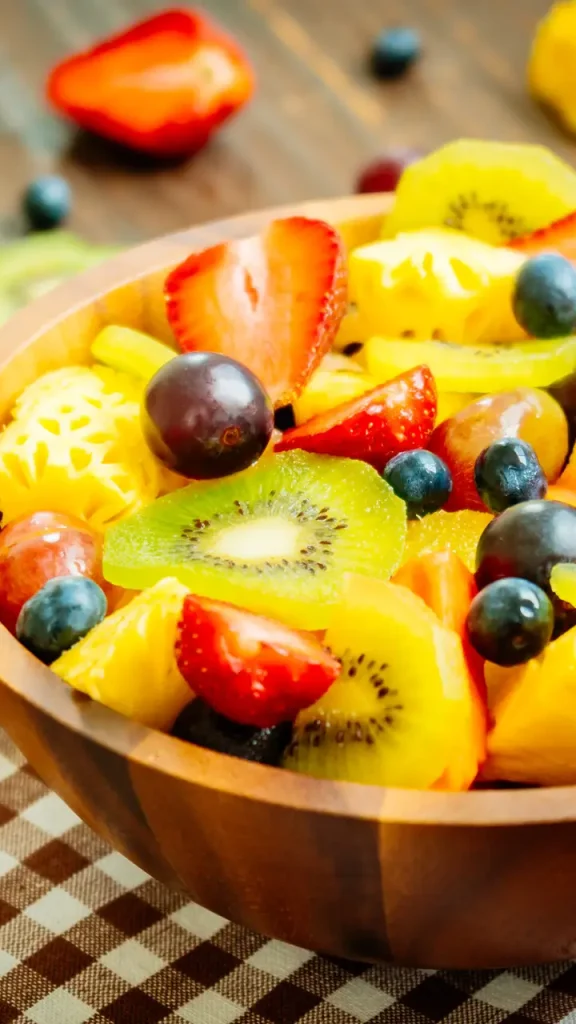 Mixed and assorted fruits with kiwi strawberry grape and other in bowl on wood table - Filter Processing